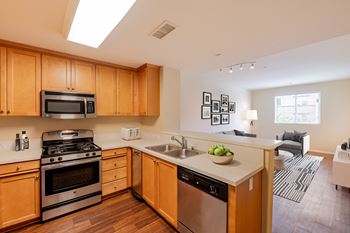 a kitchen with wooden cabinets and stainless steel appliances  at Ventana Senior Apartments, Northridge, CA